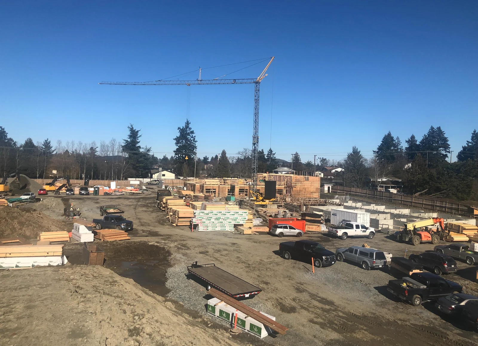 Active multifamily construction site with tower crane
